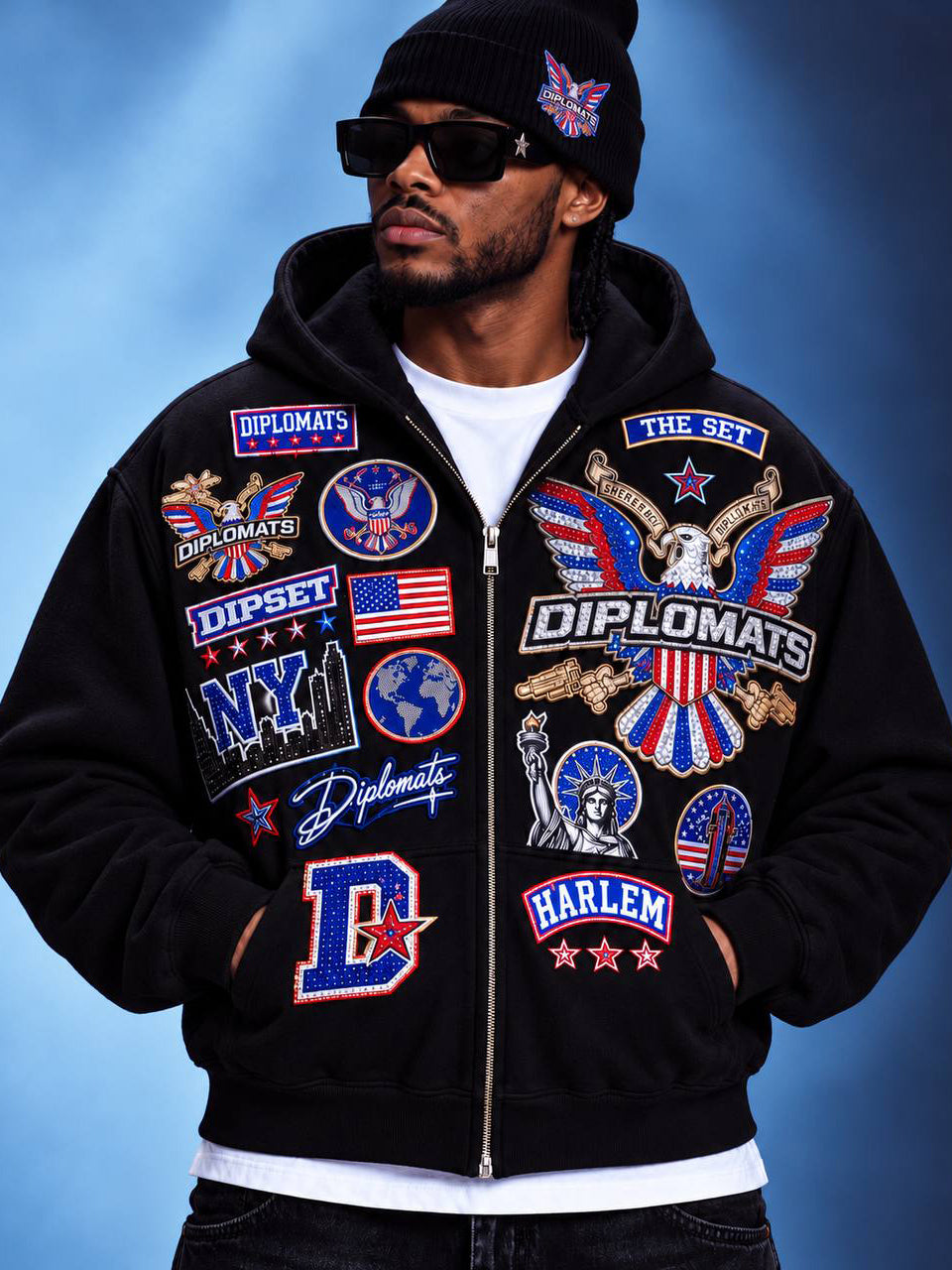 Man wearing black Diplomats iced patch zip-up hoodie, front view with Dipset and Harlem patch graphics