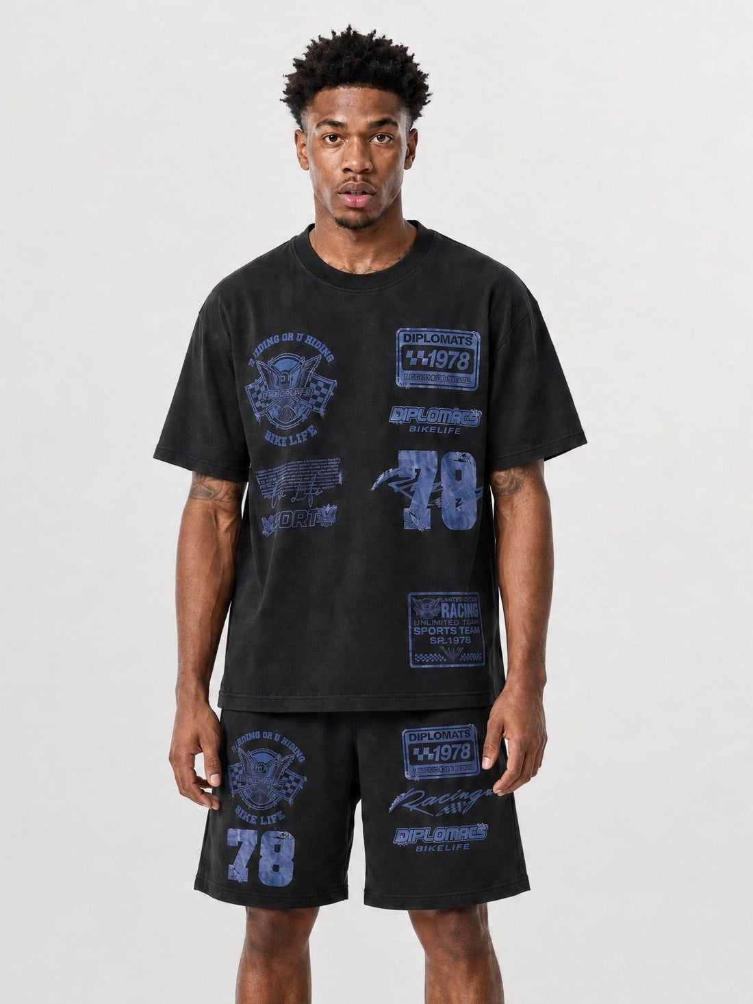 Man wearing washed black Diplomats Bike Life matching t-shirt and shorts set with racing-inspired graphics