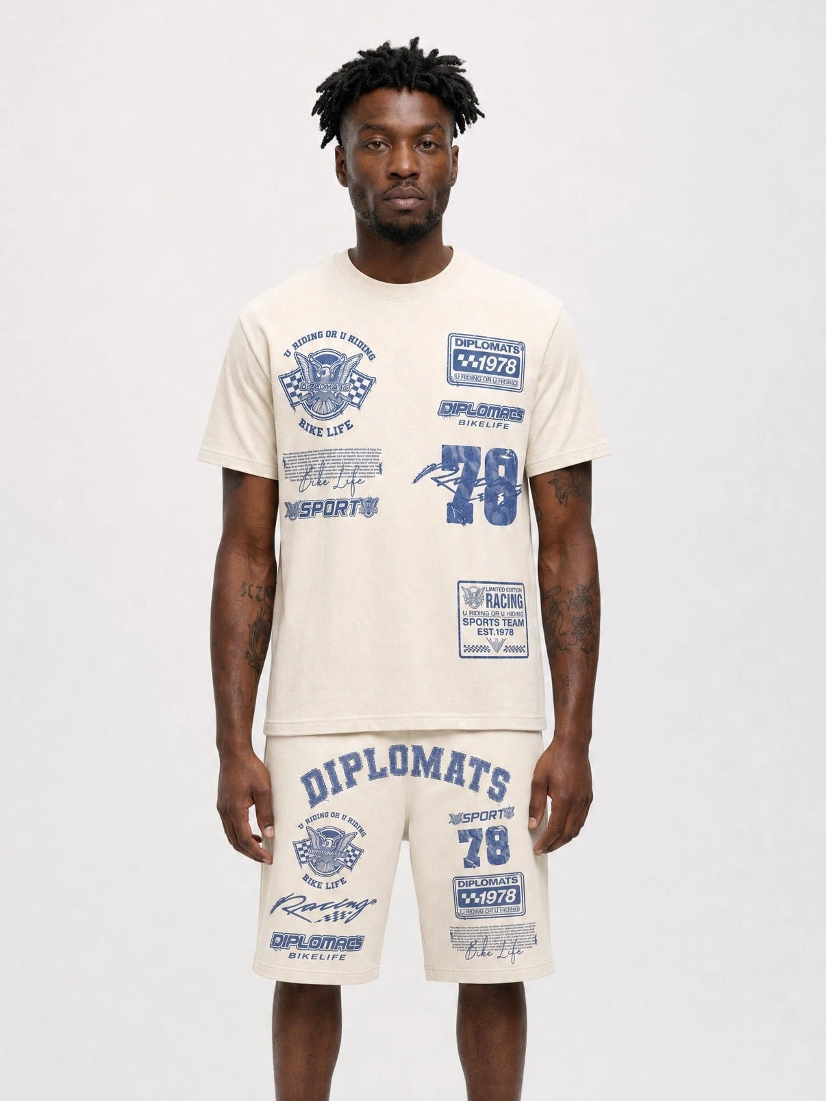 Man wearing cream Diplomats Bike Life matching t-shirt and shorts set with racing-inspired graphics